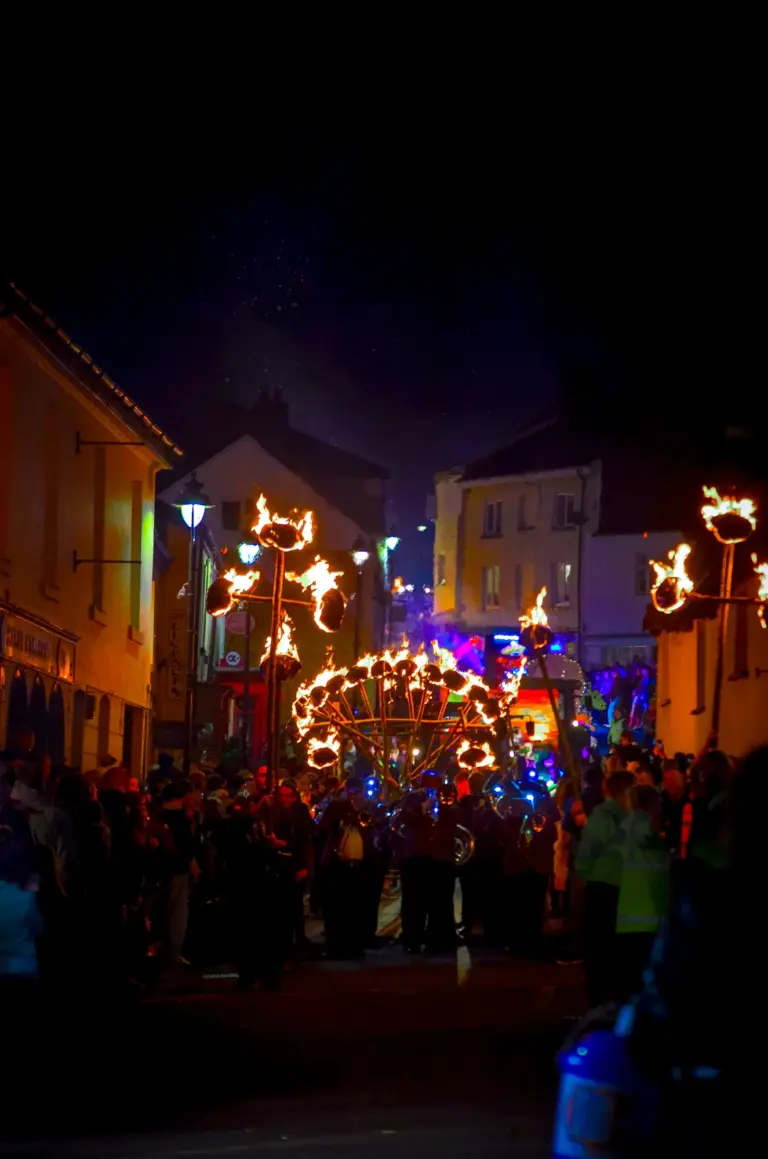 Flaming torches and a glowing fire wheel lighting up the crowded high street at night