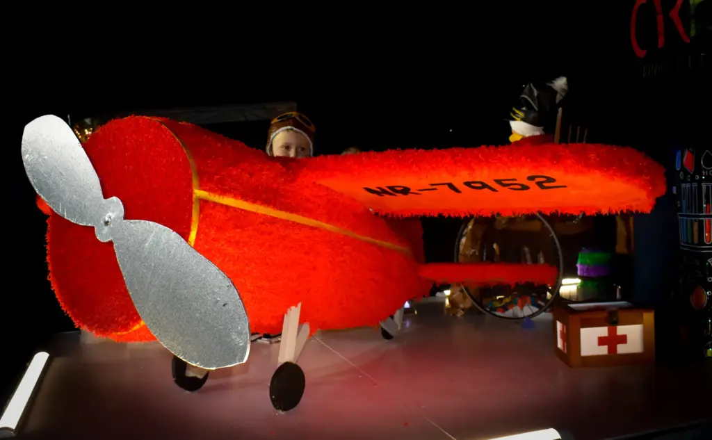 Red crepe-paper vintage aeroplane with a silver propeller on a float