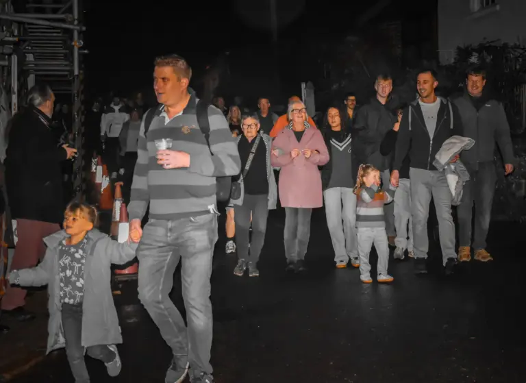 Families walking and running along the street on carnival Friday evening