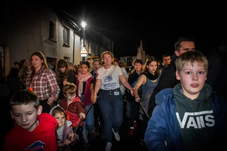 Children and adults walking through the crowded high street on carnival Friday night