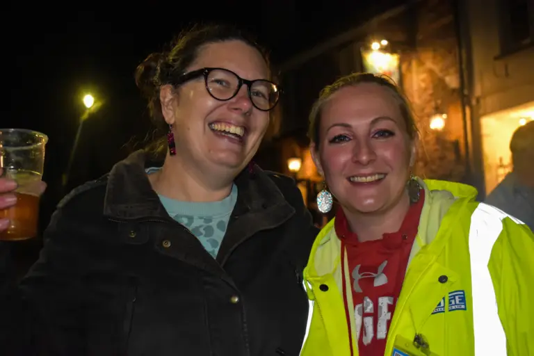 Two women laughing together, one in a hi-vis steward's jacket