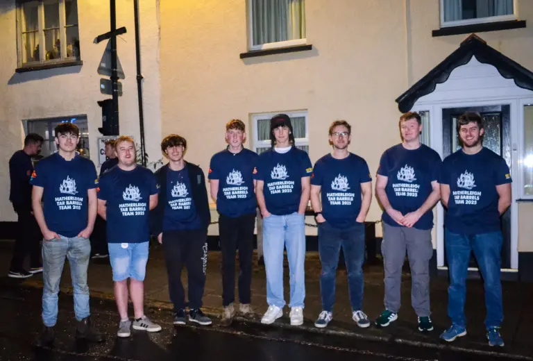 Line-up of the Hatherleigh Tar Barrels Team 2025 in matching navy T-shirts outside a house