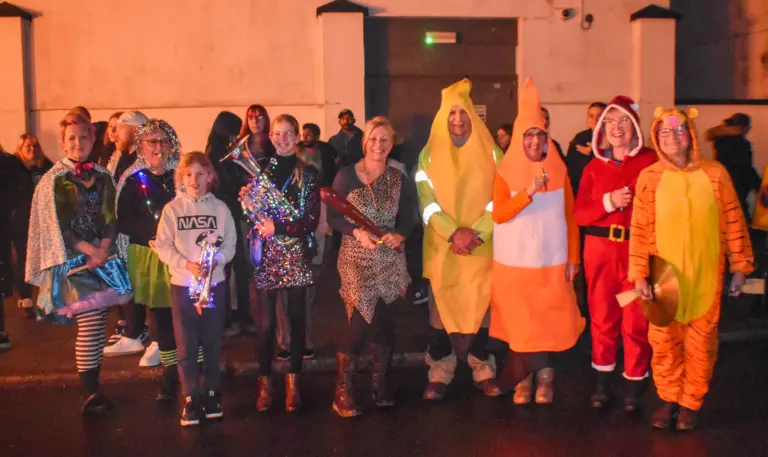Costumed entrants including a banana, a cone and Santa lined up on the street