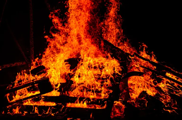 Close-up of the bonfire blazing fiercely against the black night sky