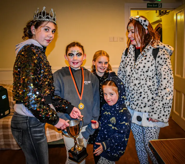 Carnival queen in a tiara presenting a trophy to the Dalmatian group