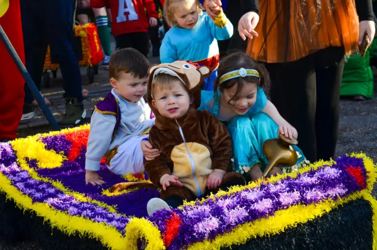 Toddlers dressed as Aladdin, a monkey and Jasmine on a crepe-paper magic carpet