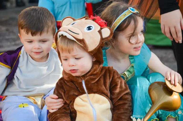 Close-up of toddlers in Aladdin and monkey costumes on the magic carpet float