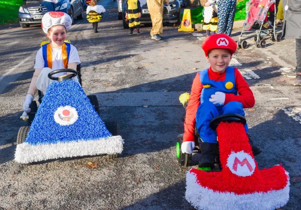 Children dressed as Mario and Toad in crepe-paper karts at the children's parade