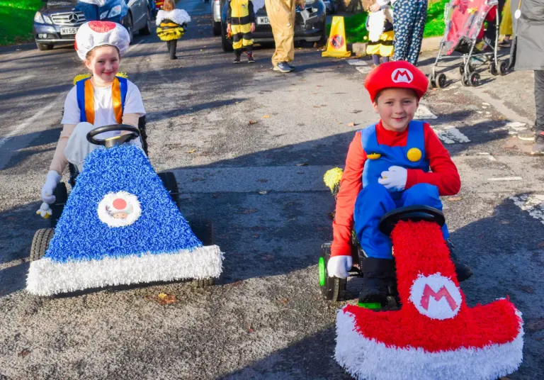 Children dressed as Mario and Toad in crepe-paper karts at the children's parade