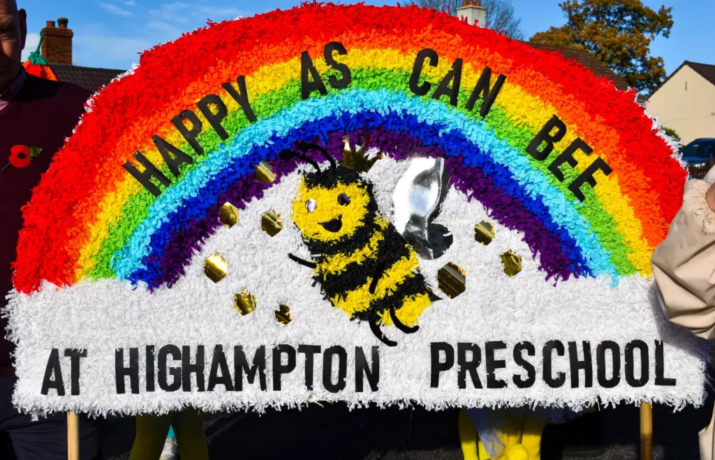 Rainbow crepe-paper banner reading Happy As Can Bee at Highampton Preschool