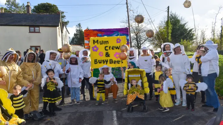 Highampton preschool group dressed as beekeepers and bees with their banner