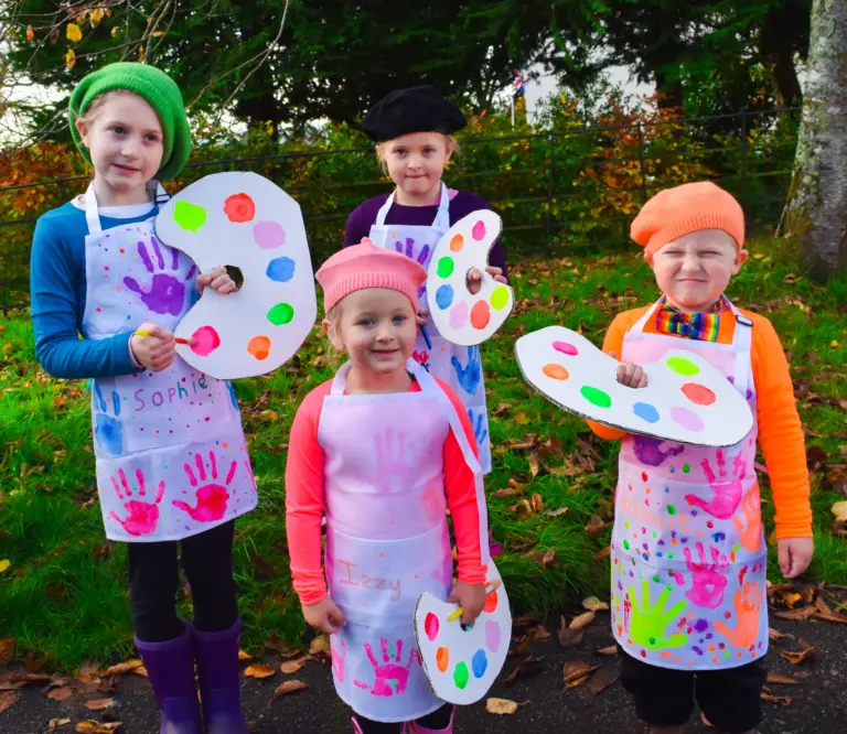 Children dressed as painters with berets, handprint aprons and paint palettes