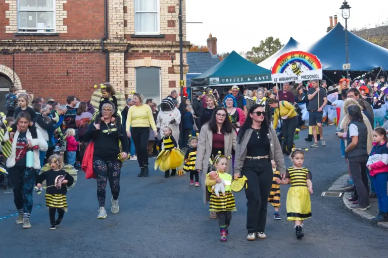 Crowds of children dressed as bees walking through the town during the afternoon parade