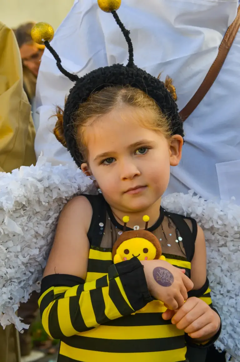 Young girl in a bee costume with antennae and fluffy wings