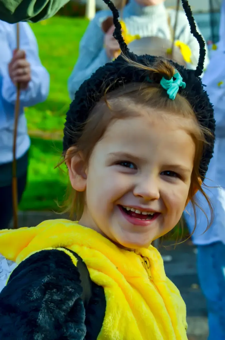 Laughing girl with bee antennae and a yellow fluffy jacket