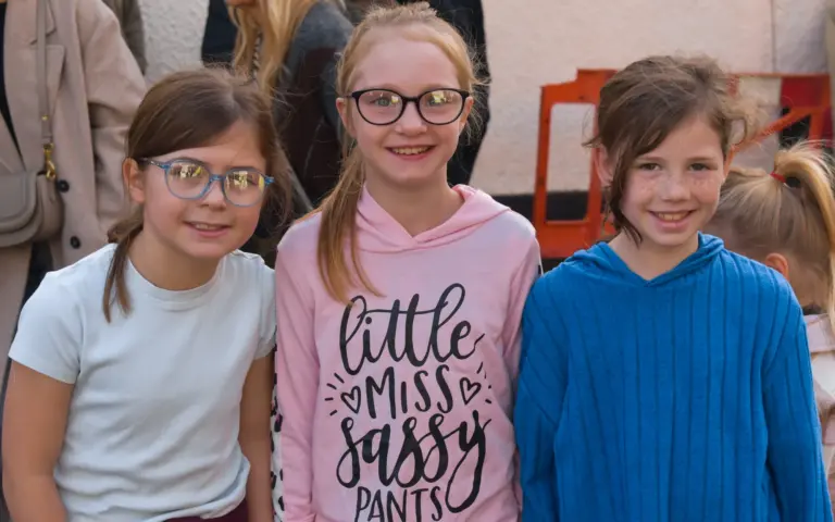 Three smiling girls in casual clothes at the Saturday morning events