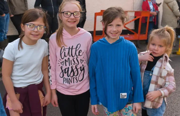 Four smiling girls posing together on Saturday morning