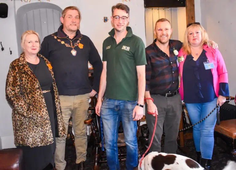 Carnival officials and judges posing together inside a local business
