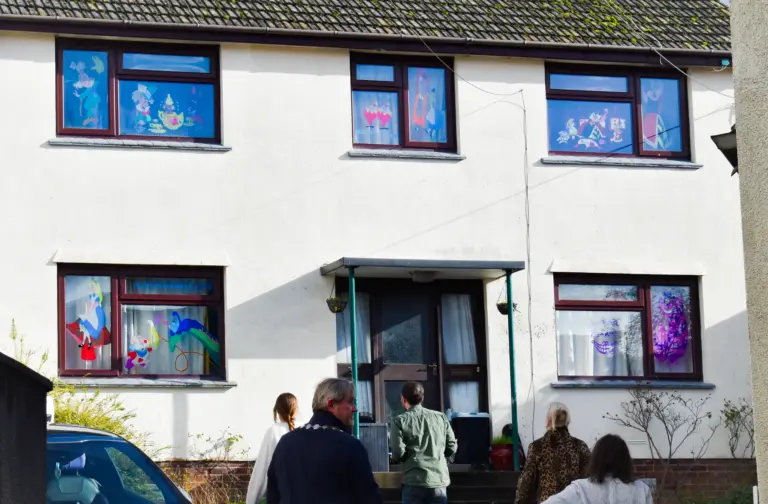 Front of a house with every window decorated for the carnival window competition