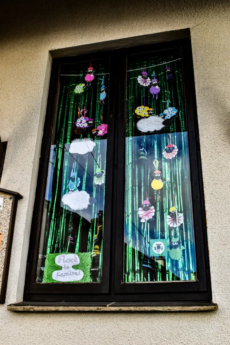 Tall window decorated with hanging flowers, clouds and fairies