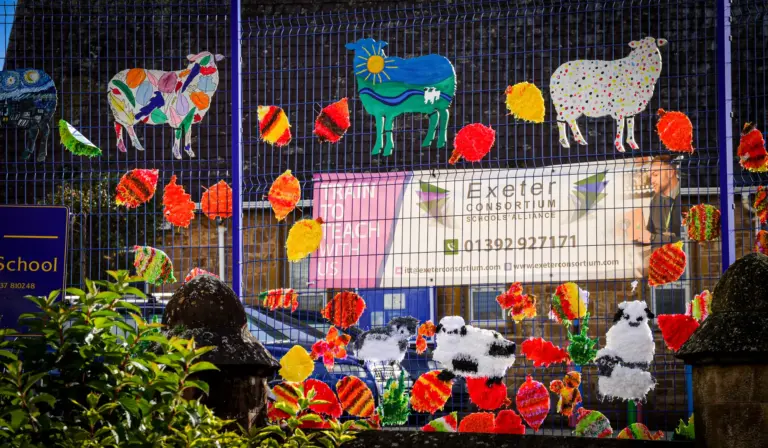 Painted sheep, cows and autumn leaves decorating the school fence