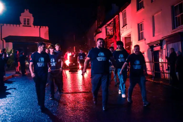 Tar Barrels Team members walking in the red and blue lit street