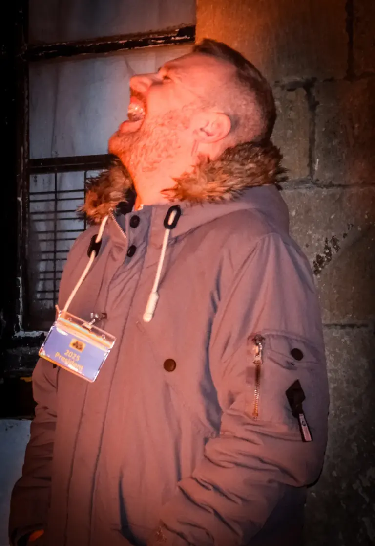 Man in a parka laughing with his head thrown back at the tar barrels night