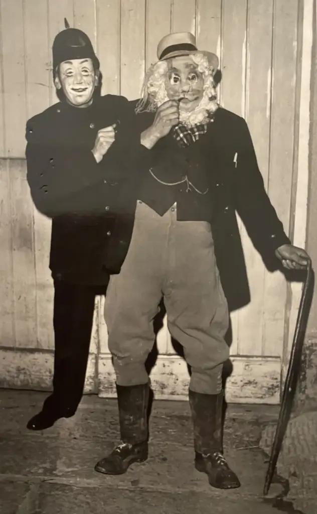 Archive photo of two masked carnival characters, a policeman and a bearded old man with a walking stick